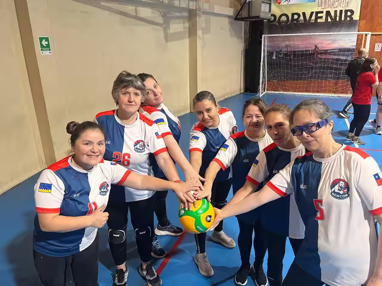 Jugadoras del Newcom de Punta Arenas juntan las manos sobre el balón en una rueda de equipo